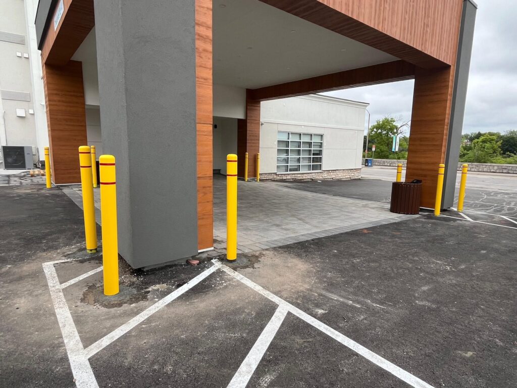 Commercial bollards protecting a building column in a parking area